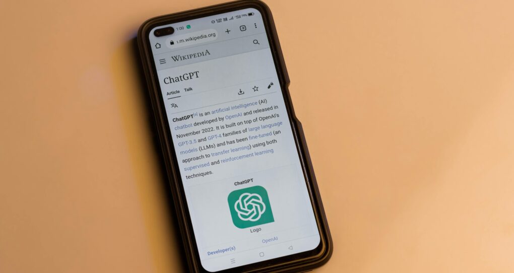 Webpage of ChatGPT, a prototype AI chatbot, is seen on the website of OpenAI, on a smartphone. Examples, capabilities, and limitations are shown.